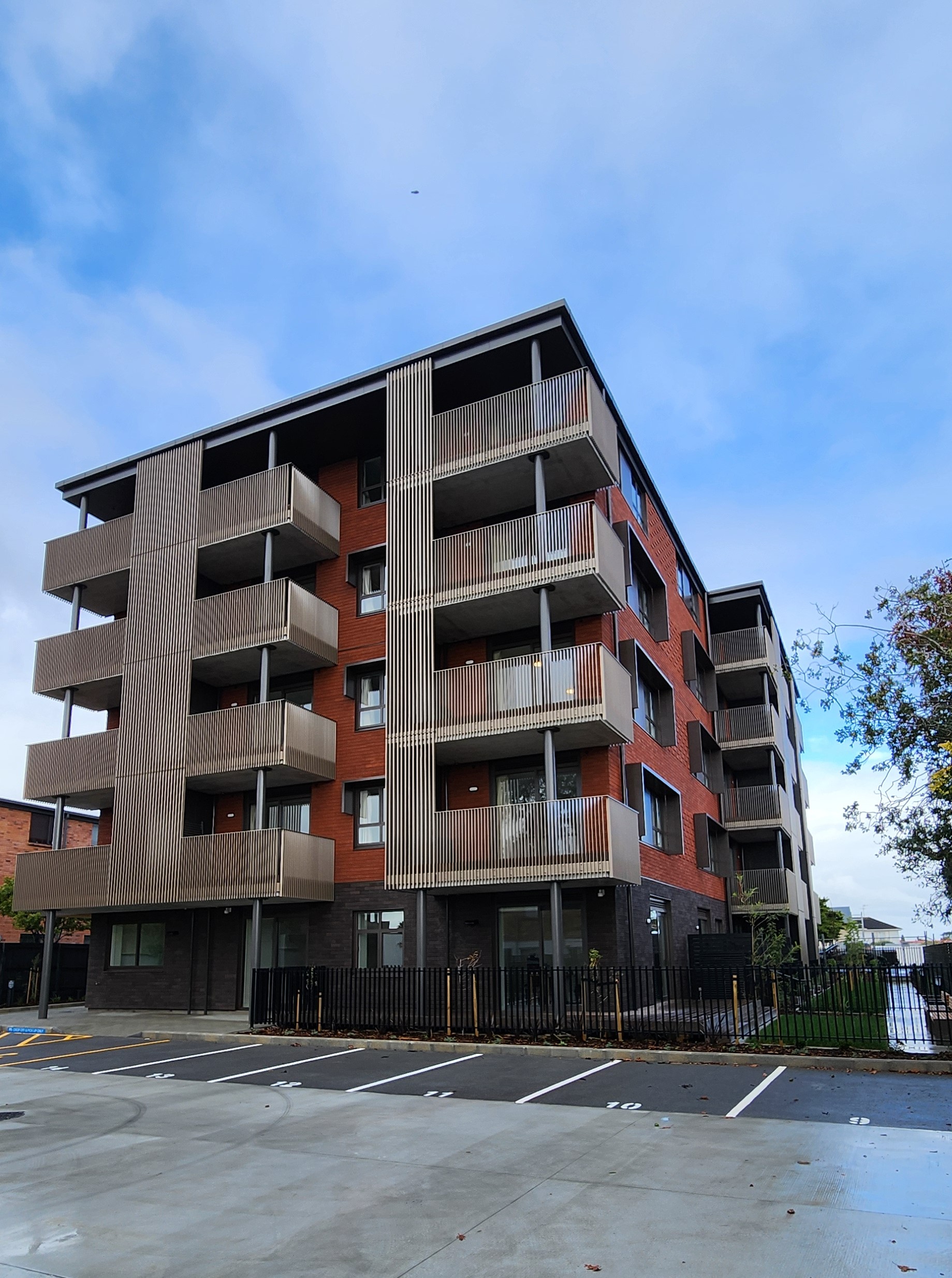 a building with balconies and a parking lot